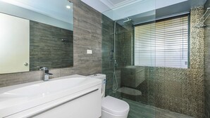 A modern bathroom with a large white sink, a toilet, and a glass-enclosed shower area. - Modern Home near Swan Valley (Beechboro)