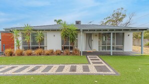 A modern two-story house with a flat roof, large windows, and a well-maintained lawn. - Modern Home near Swan Valley (Beechboro)