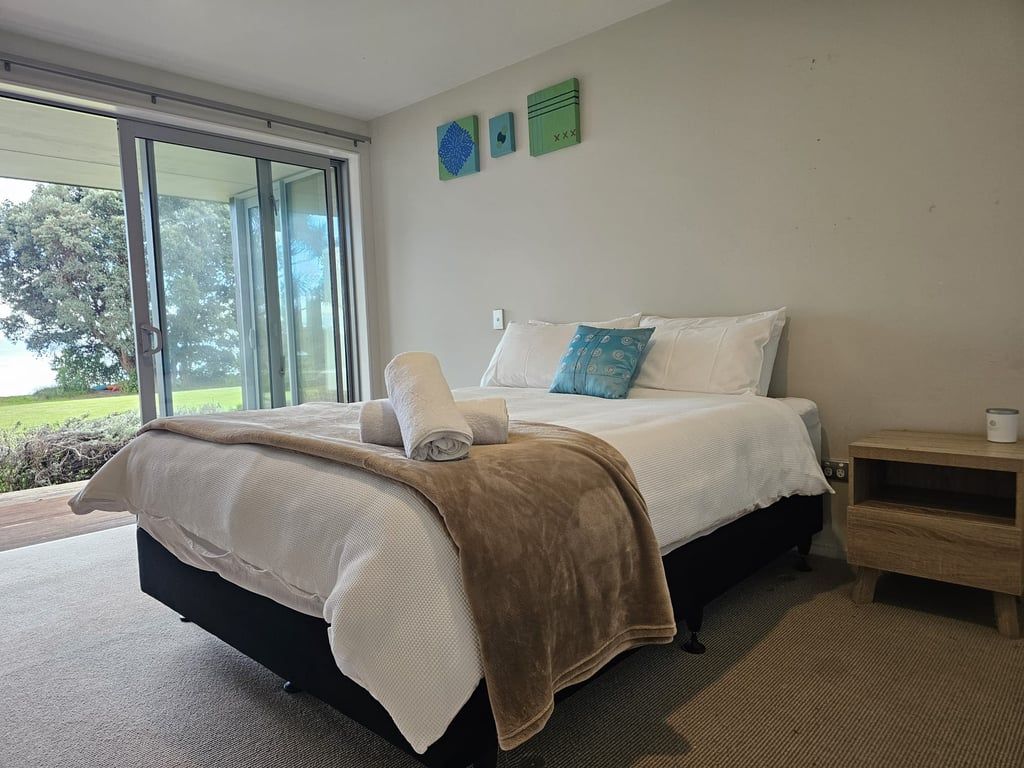 Une chambre à coucher avec un lit, une table de chevet et une fenêtre.