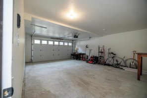Eine geräumige Garage mit Betonboden, Deckenventilator und einer großen Garagentür.