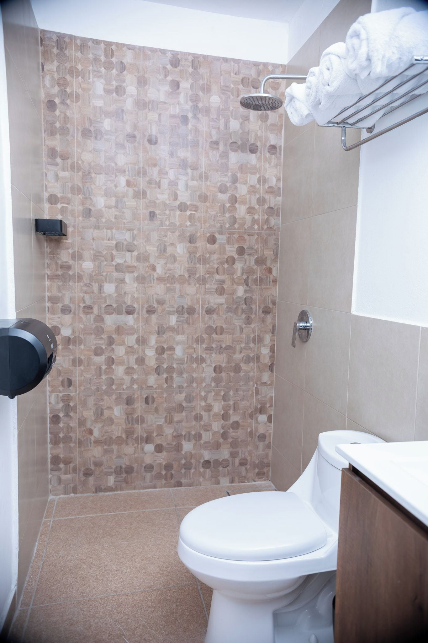 Un baño con ducha, inodoro y un perchero para toallas.