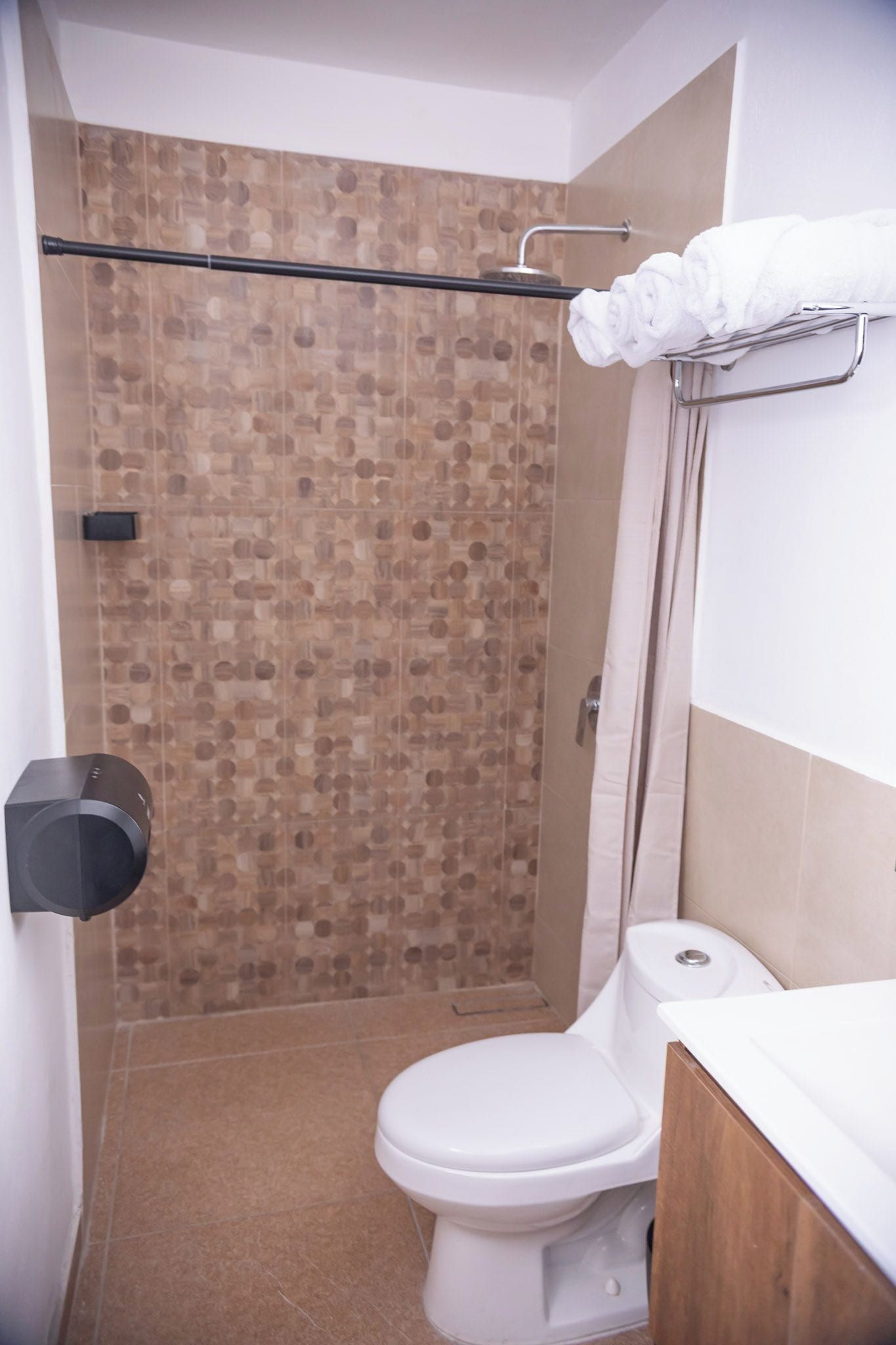 Un baño con ducha, inodoro y perchero.