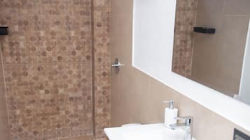A bathroom with a shower, toilet, and sink.
