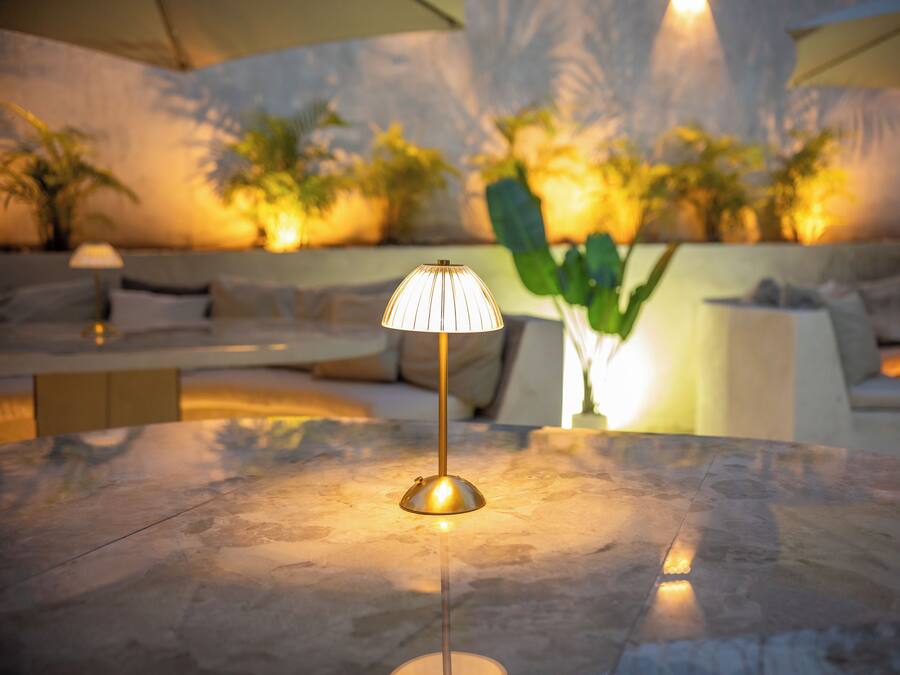 Un área de descanso moderna con una mesa de mármol, una lámpara de pie y un sofá.