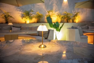 A modern lounge area with a marble table, a floor lamp, and a sofa.
