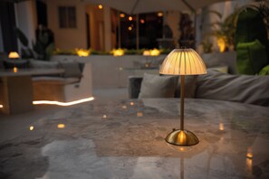 A table lamp with a metallic base and a ribbed lampshade on a marble table.