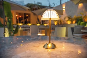 A table lamp with a clear glass shade on a marble surface.