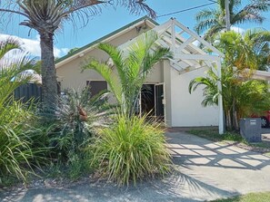 A residential building with a white exterior, a covered porch, and a driveway. - Flashpackers Hervey Bay (Torquay)
