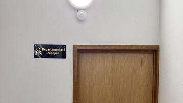 Une porte en bois, au-dessus de laquelle est affichée une plaque indiquant « Departamento 2, Zapopan ».