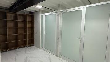 A room with a marble floor, a wooden shelving unit, and a set of sliding doors.