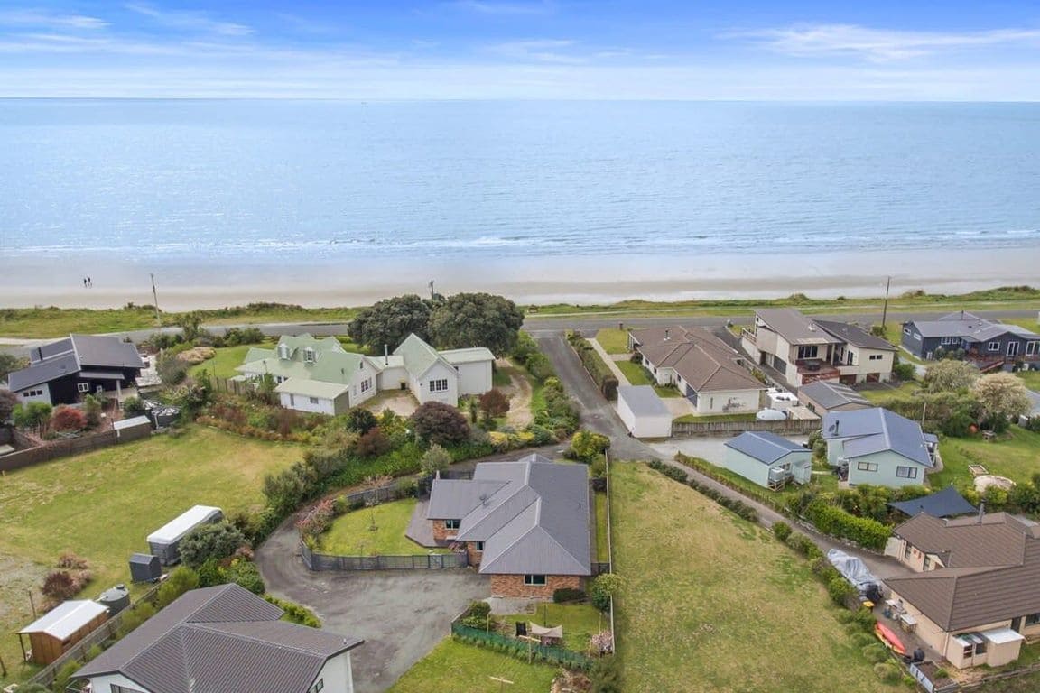 A residential area with houses, a beach, and a clear sky.