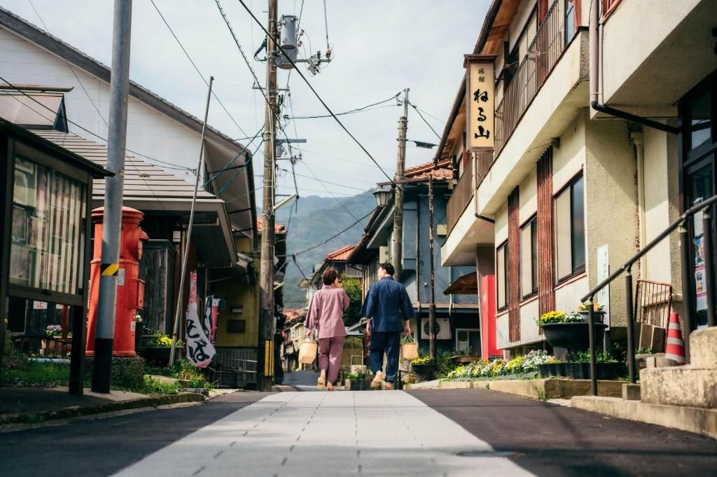 A narrow street with traditional buildings, a clear sky, and a couple walking.