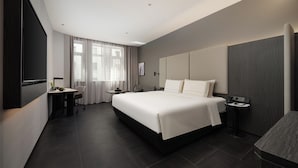A modern hotel room with a large bed, bedside tables, a desk, and a flat-screen TV. - Atour Hotel Dalian Xinghai Gaorji Road (Dalian)