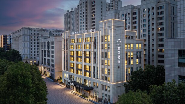 A modern hotel building with a prominent sign, surrounded by high-rise residential buildings. - Atour Hotel Dalian Xinghai Gaorji Road (Dalian)