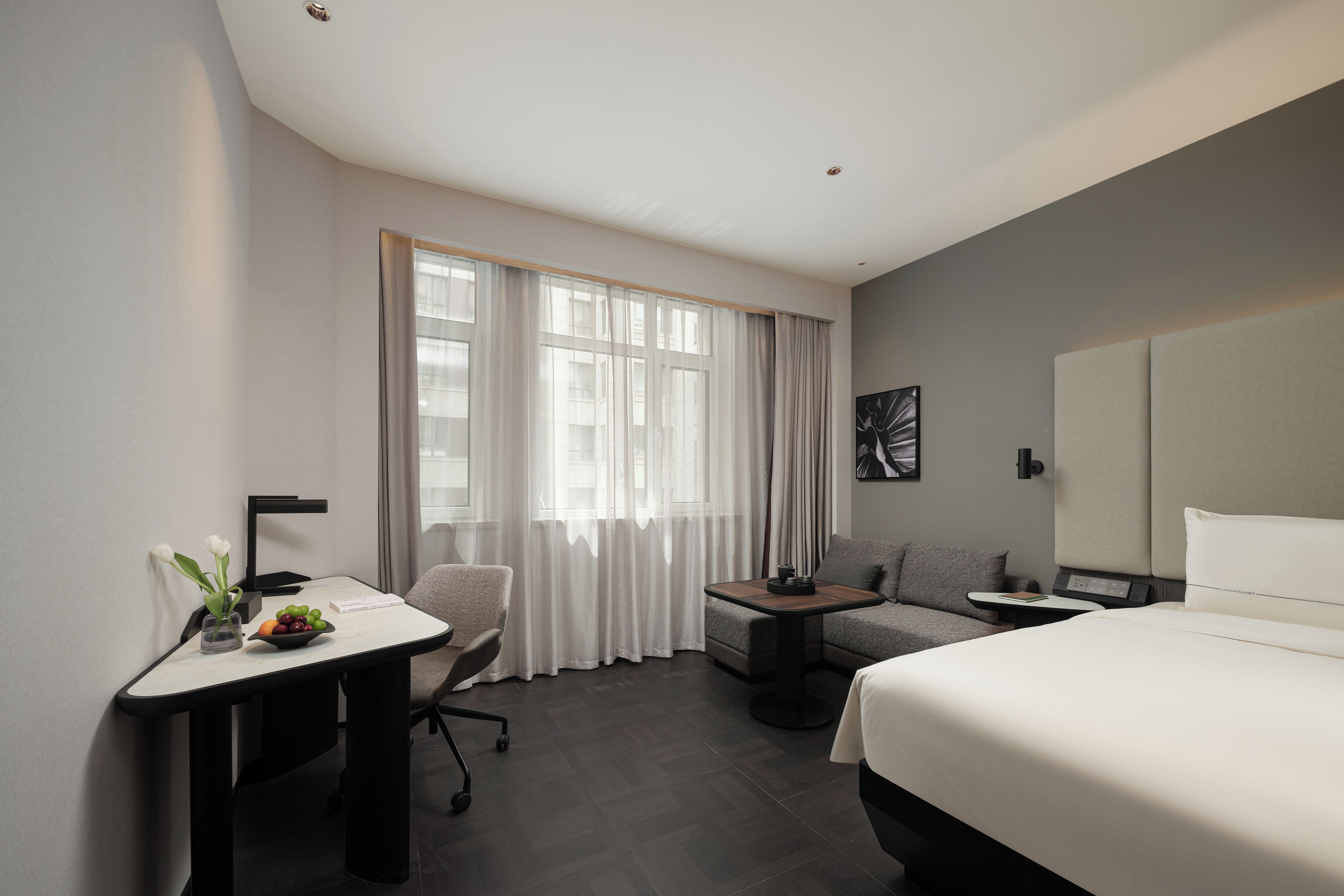 Una habitación de hotel con una cama, un escritorio, una silla, un sofá y una mesita.
