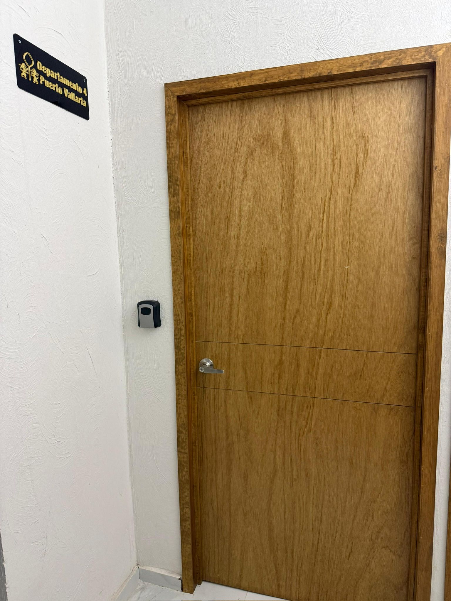 A wooden door with a keyhole and a doorbell.