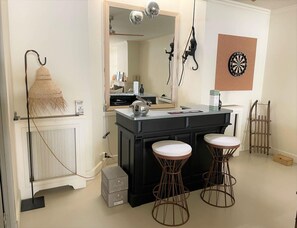 A modern bathroom with a black vanity, two stools, a mirror, and a wall-mounted dartboard. - Gorgeous 18th-century Villa, Maillane (Maillane)