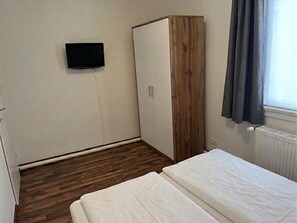 A room with a bed, a wardrobe, a television, and a window with curtains. - Alpine downtown apartment near top ski resorts (Tamsweg)