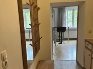 A hallway leading to a room with a window, a door, and a small table with a chair. - Alpine downtown apartment near top ski resorts (Tamsweg)