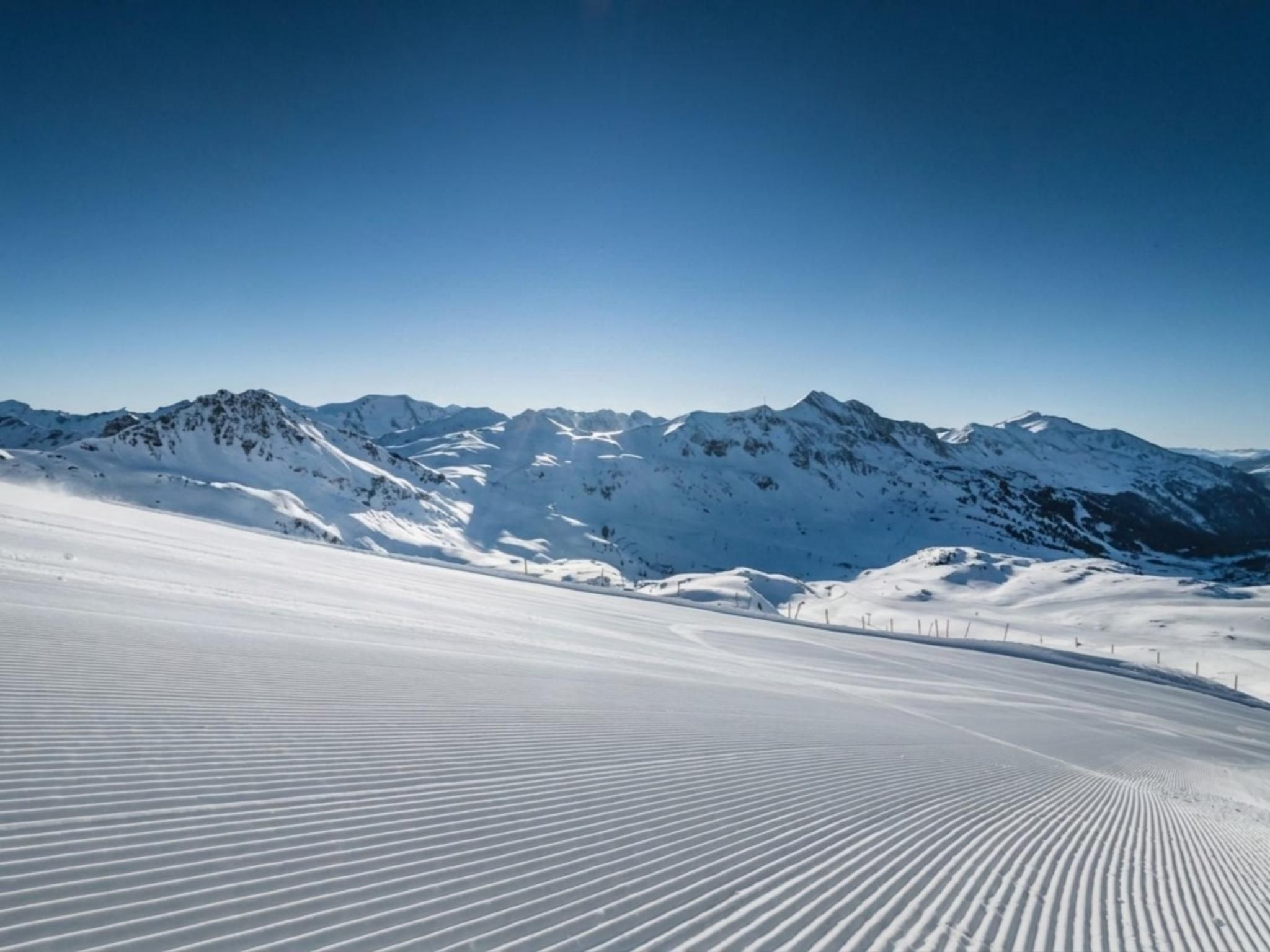Paisagem montanhosa coberta de neve sob um céu limpo.
