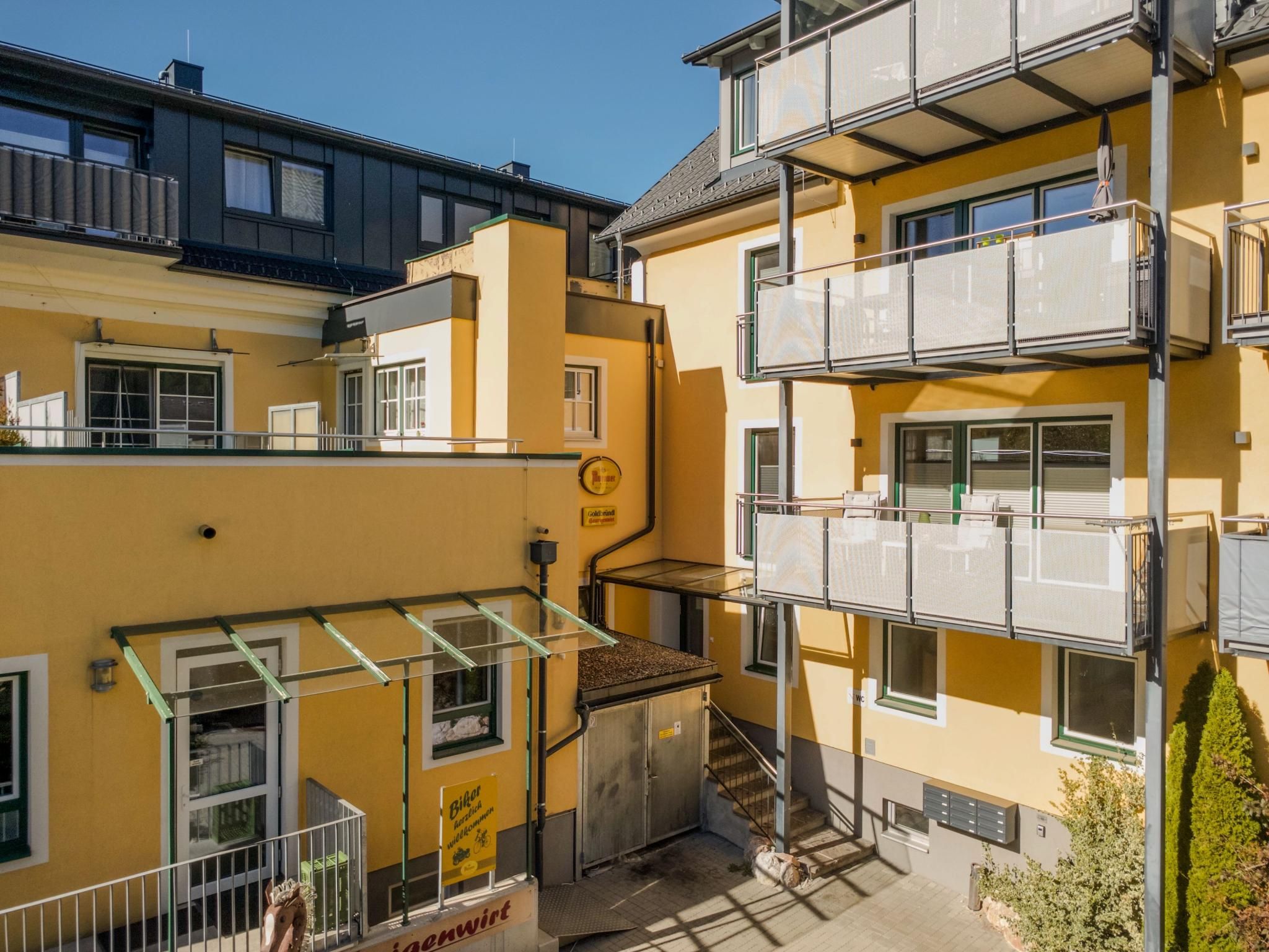 A multi-story residential building with balconies, a visible staircase, and a sign indicating a bike rental service.