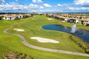 A golf course with bunkers, a pond, and a fountain. - Luxury Villa With Pool And Arcades (Four Corners)