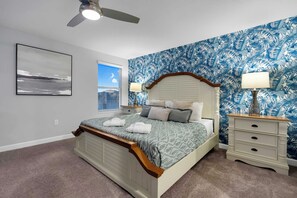 A bedroom with a bed, a nightstand, a lamp, a ceiling fan, and a window with blinds. - Luxury Villa With Pool And Arcades (Four Corners)
