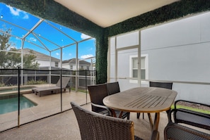A covered patio area with a pool, outdoor furniture, and a view of the neighborhood. - Luxury Villa With Pool And Arcades (Four Corners)