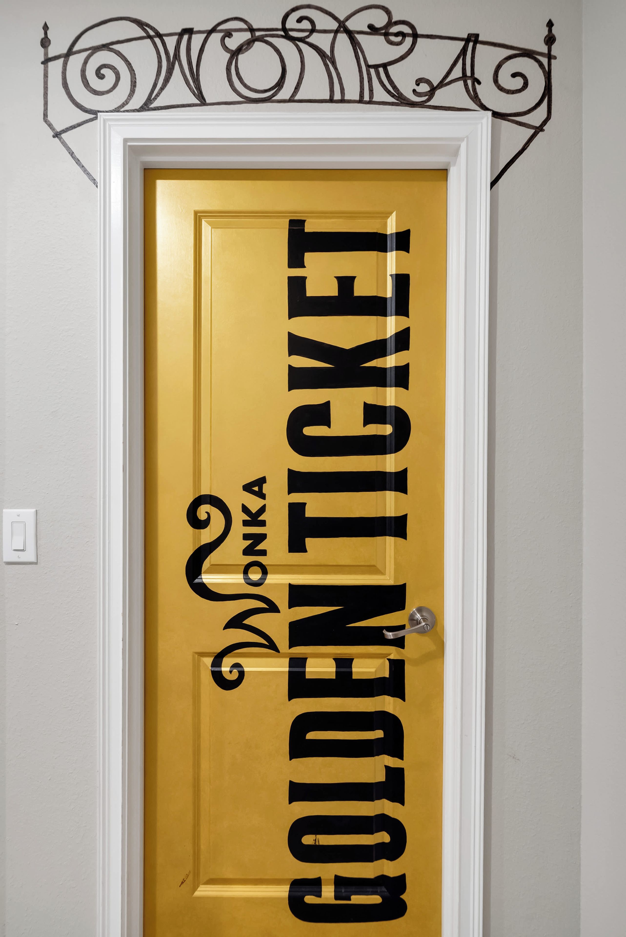 Eine Tür mit einem goldenen Ticket-Design und der Aufschrift 'WONKA'.