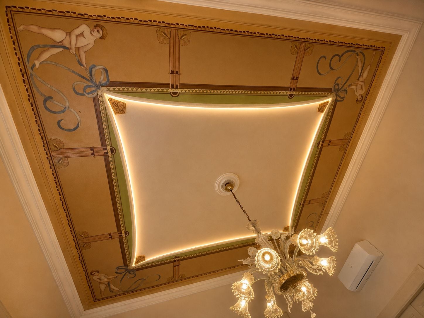 A ceiling with ornate moldings and a chandelier.