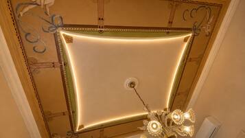 A ceiling with ornate moldings and a chandelier.