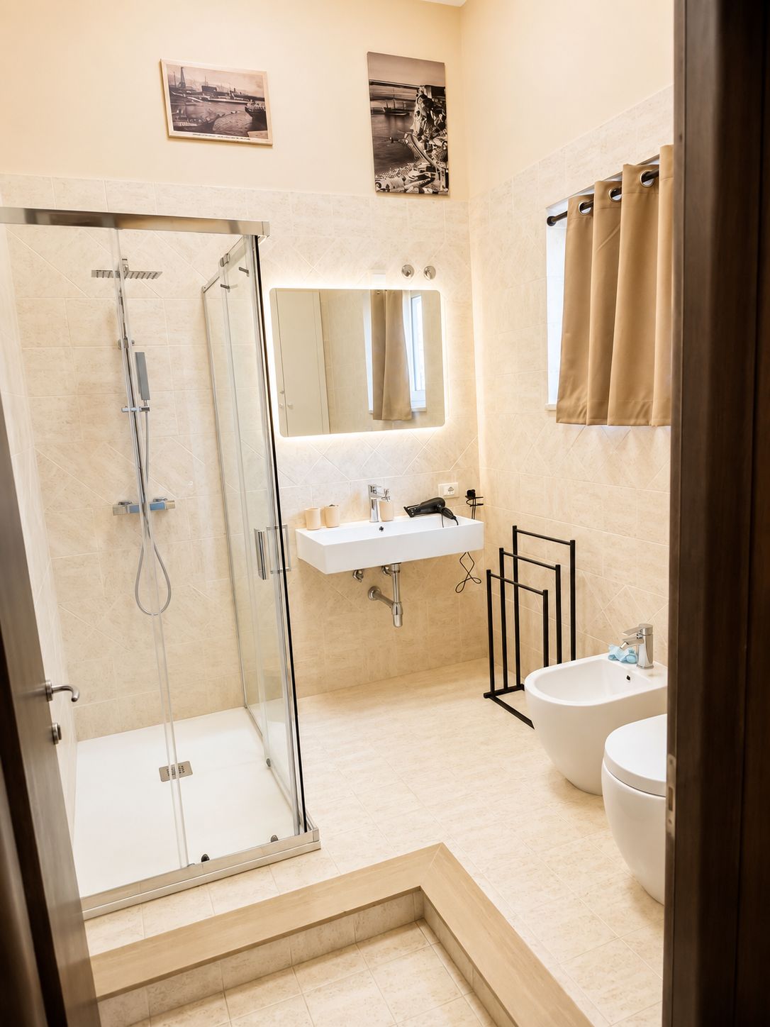 Une salle de bain moderne avec une douche à parois de verre, un lavabo, un bidet et des toilettes.