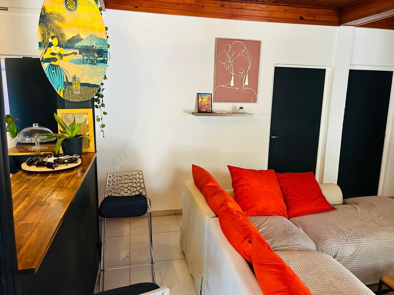 Habitación pequeña con cama, un escritorio y una estantería con un cuadro.