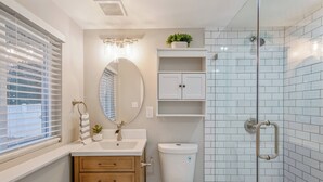 Ein Badezimmer mit Toilette, Waschbecken, Spiegel und Dusche.
