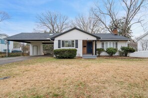 A single-story house with a front porch, a garage, and a small front yard. - 8 Bells Bungalow - Cozy, Stylish, Prime Location (Annapolis)