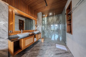 A modern bathroom with a wooden vanity, a large mirror, and a glass-enclosed shower area. - Andara Hide Ubud villa (Gianyar)