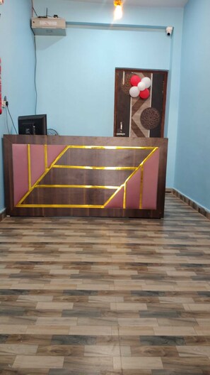Una recepción con un diseño geométrico, una computadora y una cámara de seguridad en la pared.