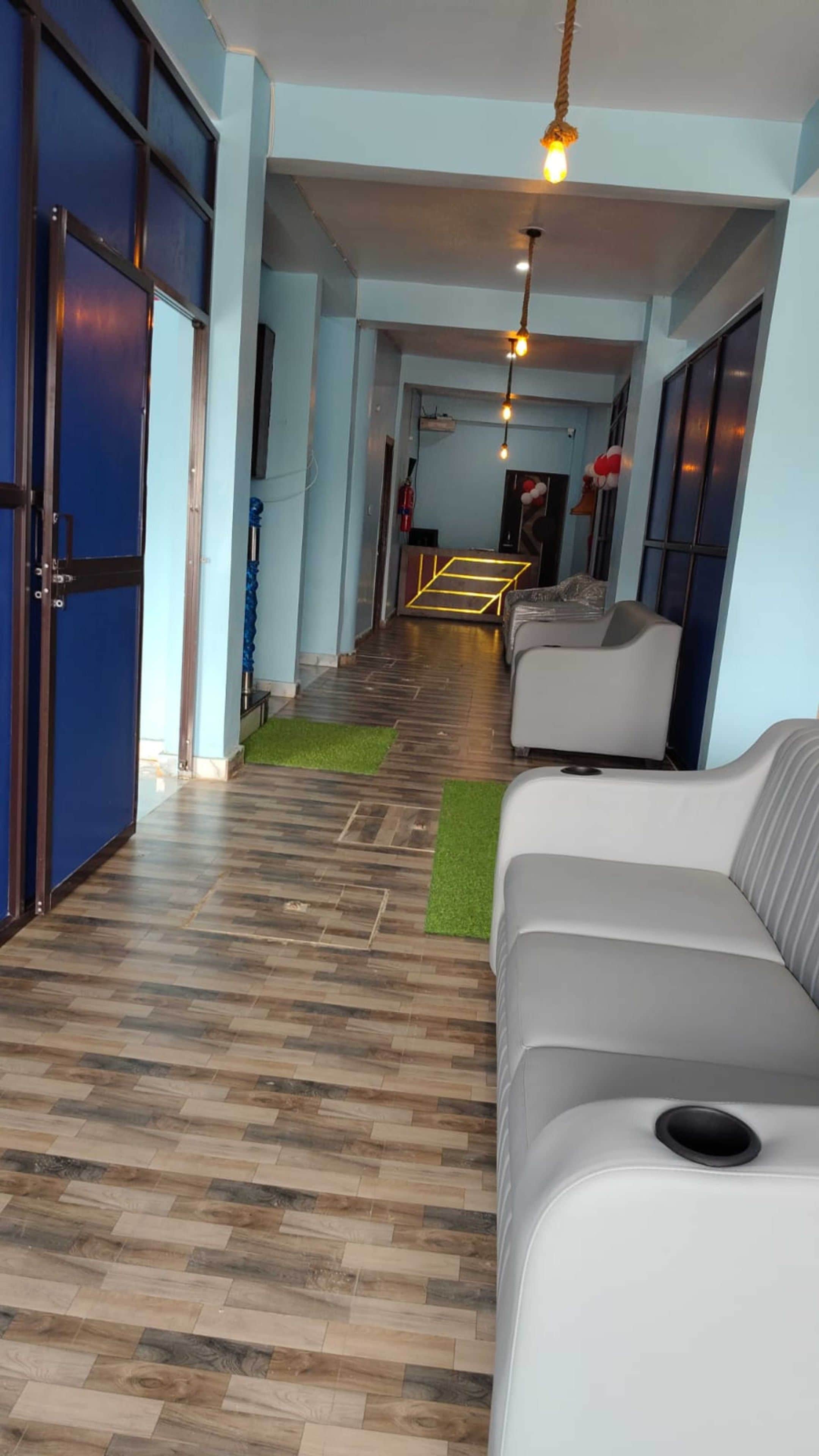 Un pasillo de hotel con suelo de madera, un sofá y una puerta.