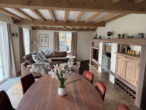 A cozy living room with a wooden dining table, comfortable seating, and a fireplace.