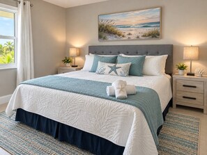 A neatly made bed with a blue and white bedspread, a starfish pillow, and a pair of rolled towels on the bed. - Port Charlotte Pool Retreat (Port Charlotte)