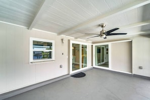 A spacious room with a ceiling fan, large sliding glass doors, and a window. - Port Charlotte Pool Retreat (Port Charlotte)