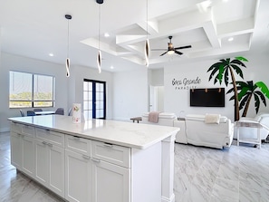 A modern kitchen with a large island, white cabinetry, and pendant lighting. - Boca Grande Retreat 4BR 2BA Waterfront Sleeps 12 (Port Charlotte)