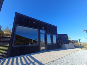Een modern gebouw met grote ramen en een donkere gevel.