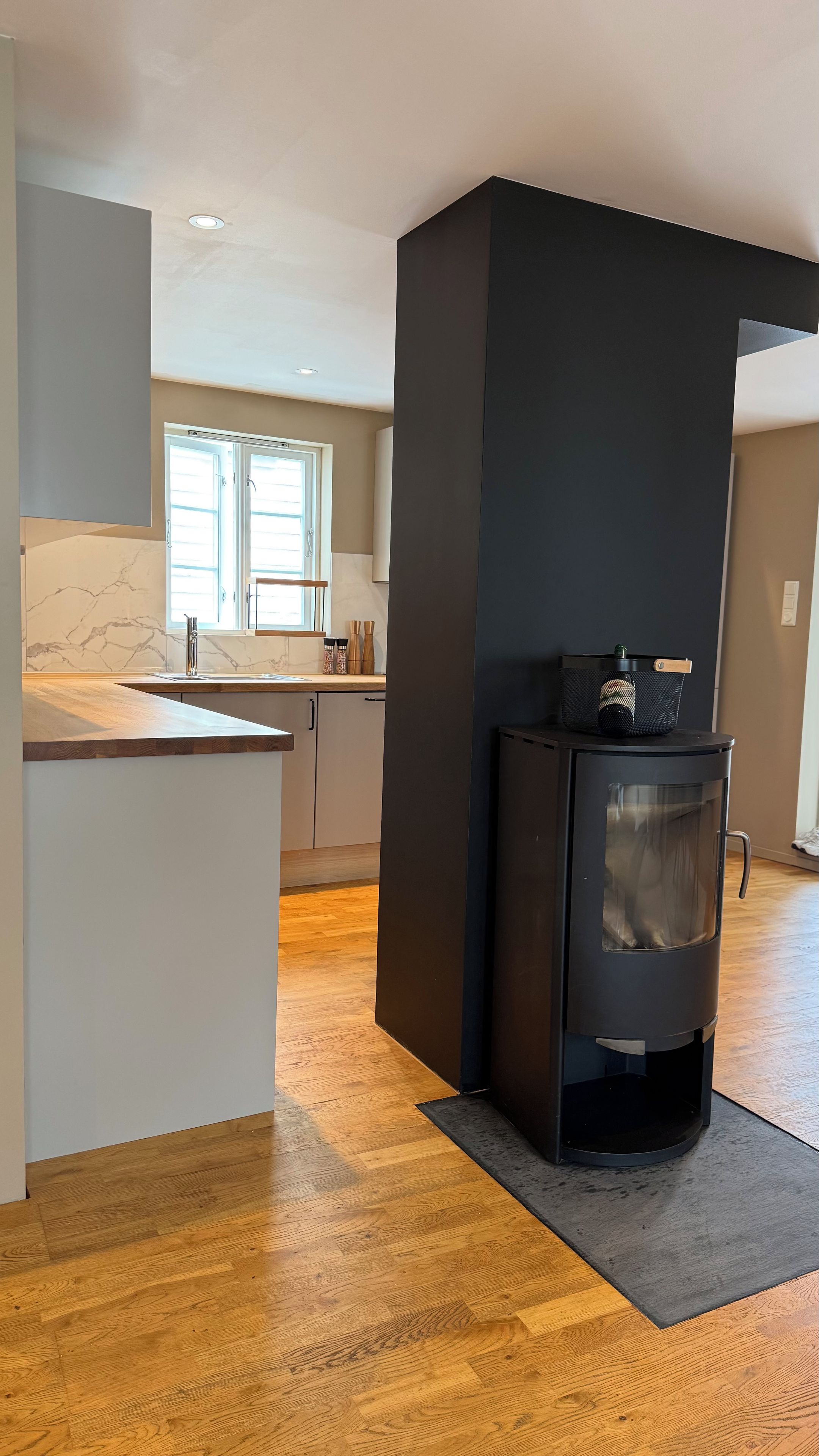 A modern kitchen with a central island, a built-in stove, and a window providing natural light.