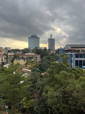 A cityscape with modern buildings, dense greenery, and a cloudy sky. - Luxury 2 Bedroom Apartment With Pool in Westlands, Skynest (Nairobi)