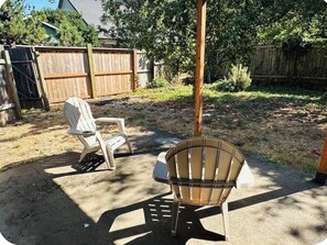An outdoor patio area with two chairs and a wooden fence in the background. - Gorgeous 3-bedroom house with AC in charming Eugene (Eugene)