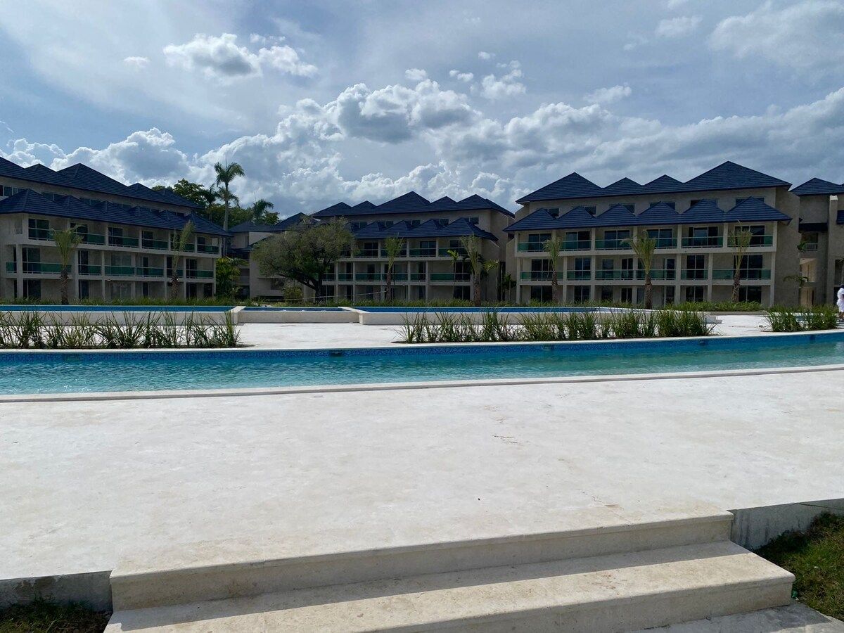 Un hôtel composé de plusieurs bâtiments, doté d’une piscine et offrant une vue sur un ciel dégagé.