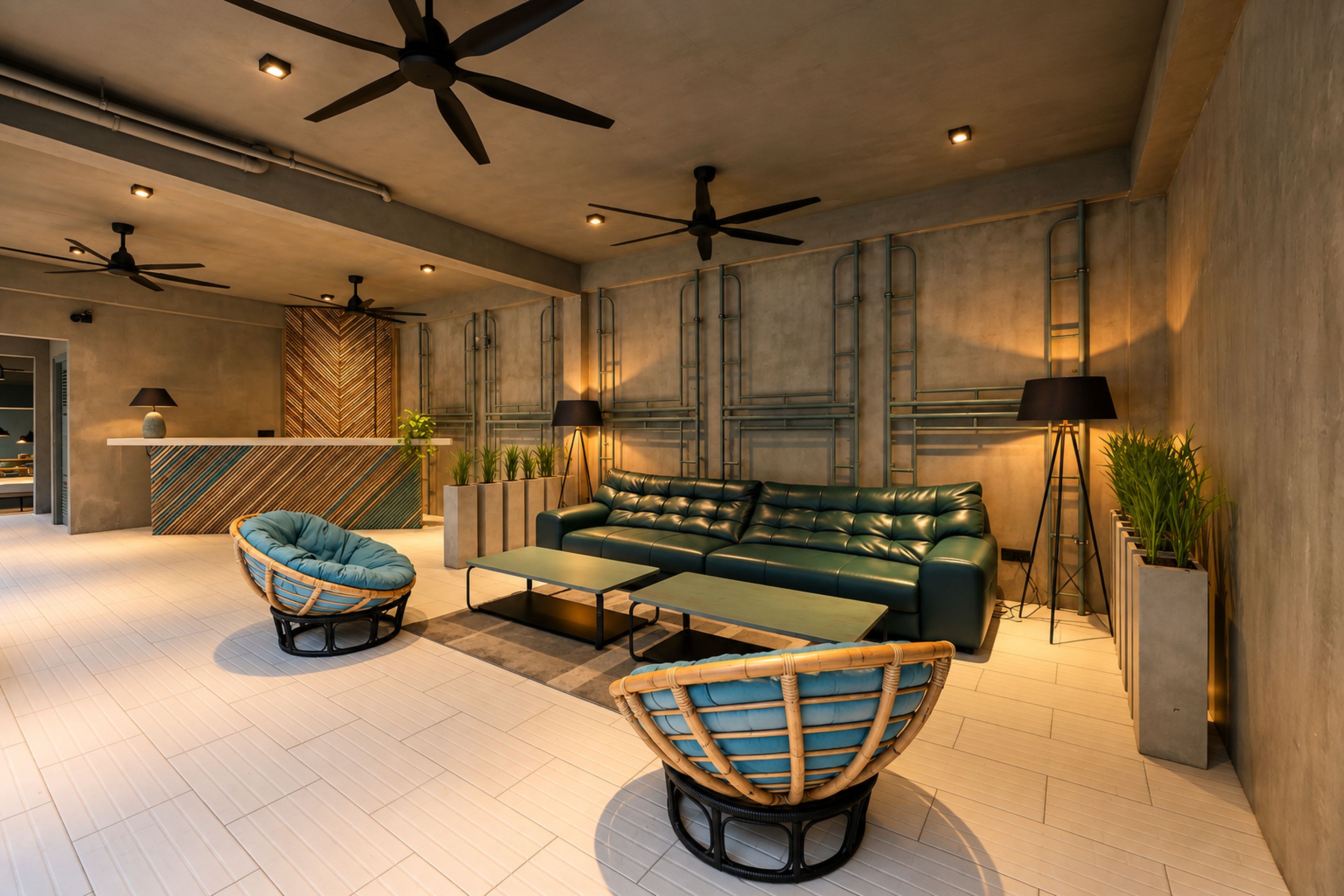 A modern lounge area with a green sofa, two armchairs, a coffee table, ceiling fans, and a wall-mounted TV.