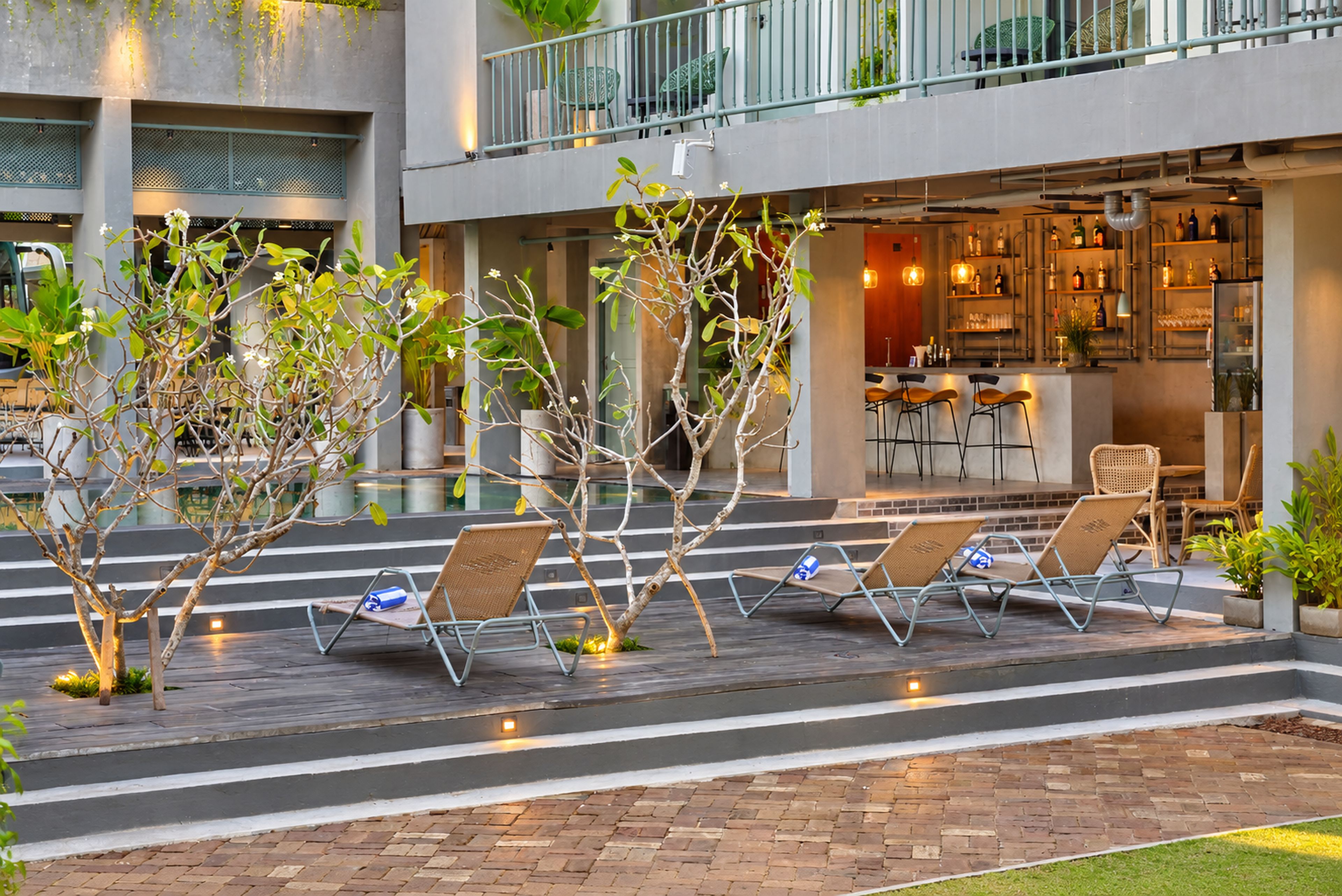 An outdoor seating area with lounge chairs and a bar area visible in the background.