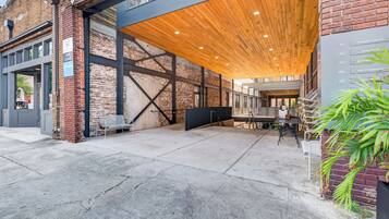 A building with a brick facade, large windows, and a covered outdoor area with a wooden ceiling.
